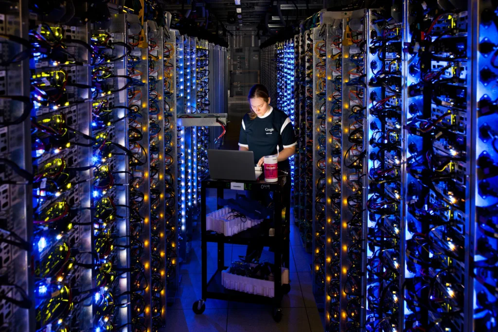 A data center technician examining the hardware components of an open, overheated server rack in a facility.